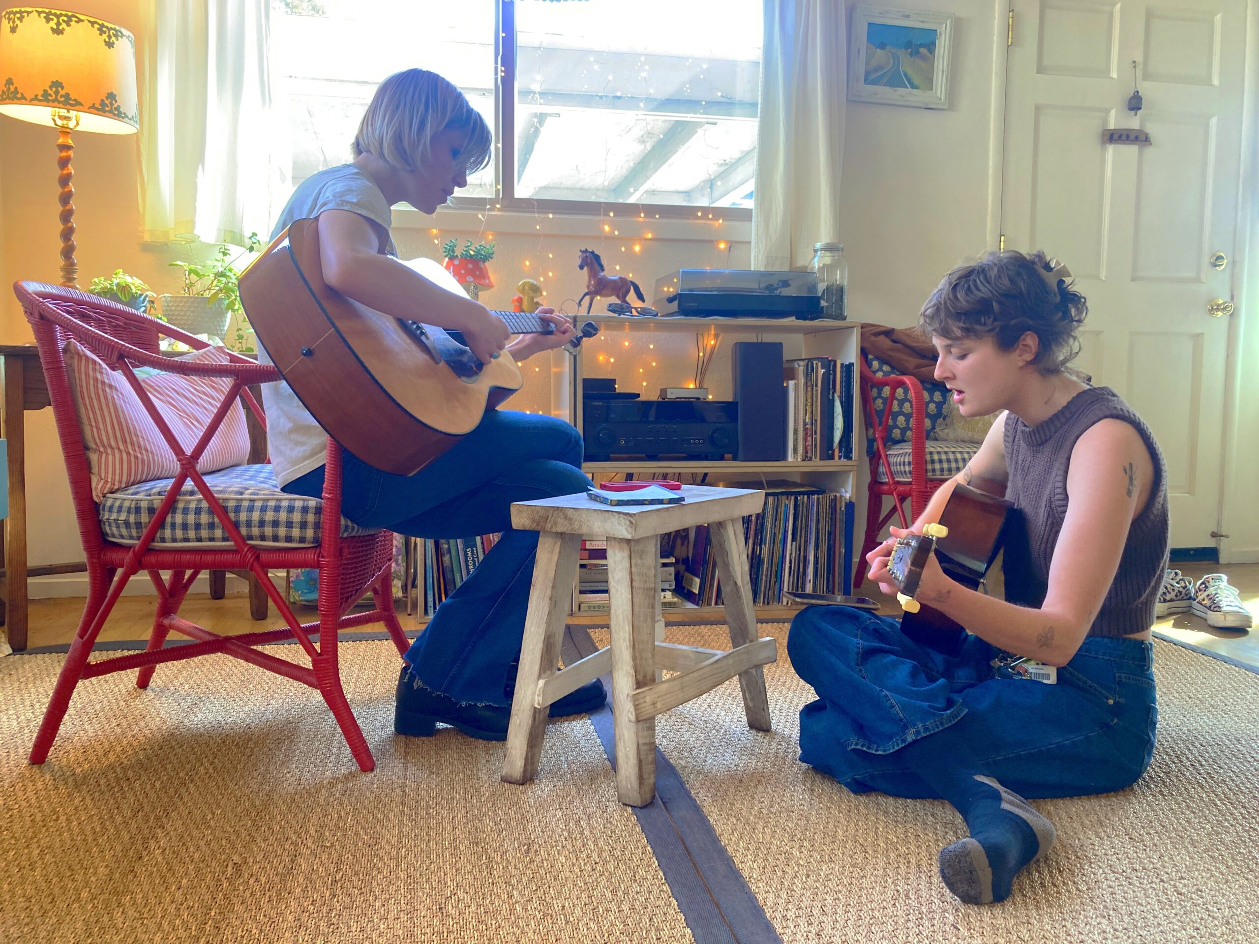 A photo of two young women practicing guitar.