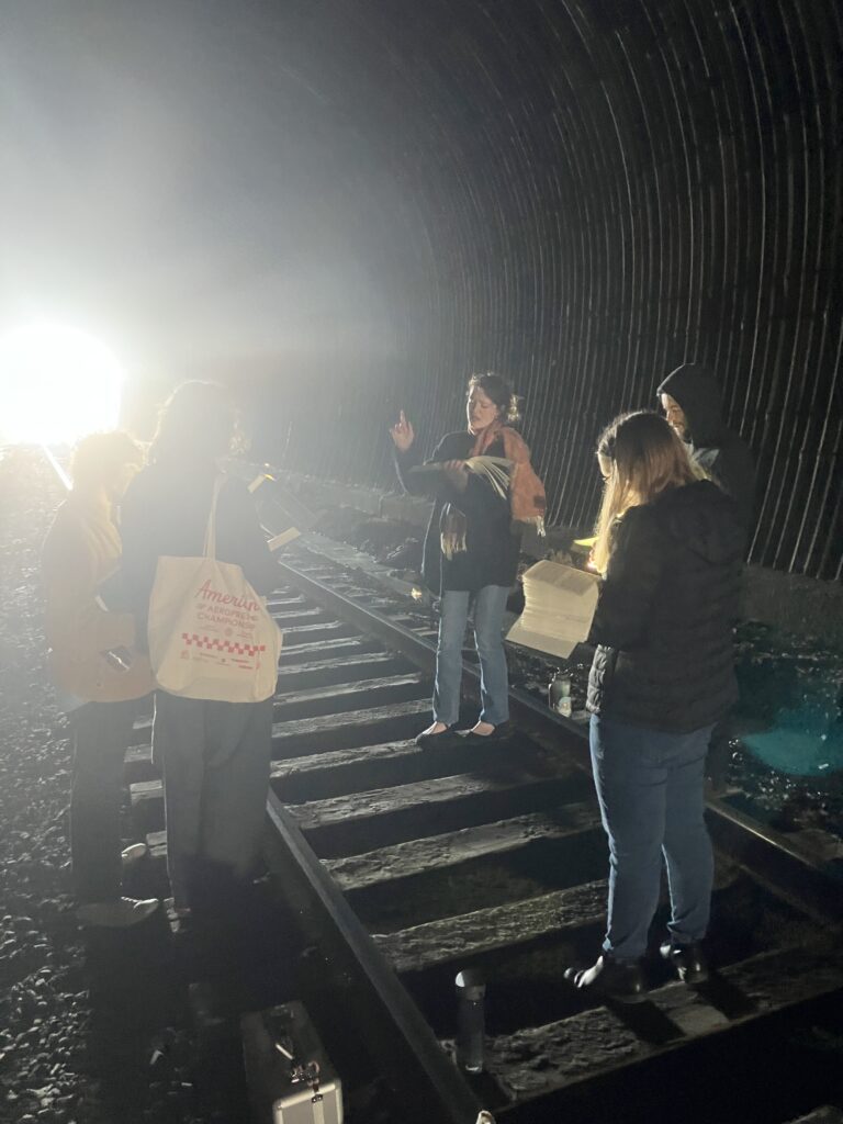 Photo of five singers in a train tunnel.