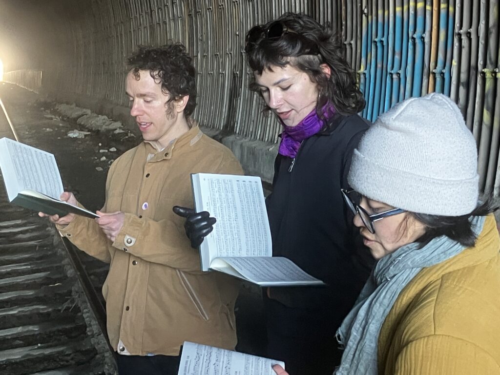 Photo of five singers in a train tunnel.