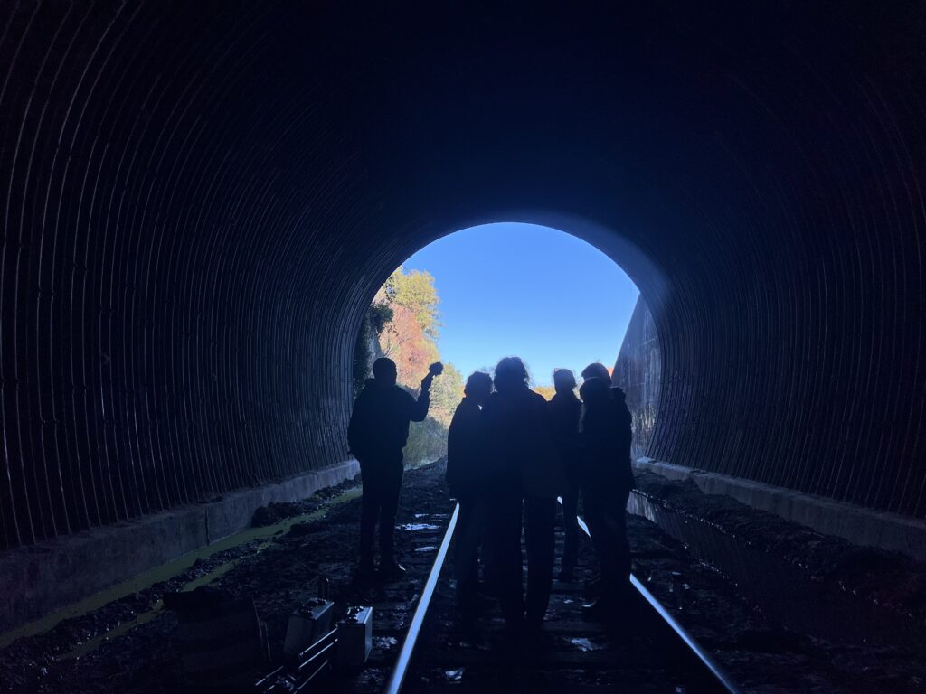 Photo of five singers in a train tunnel.