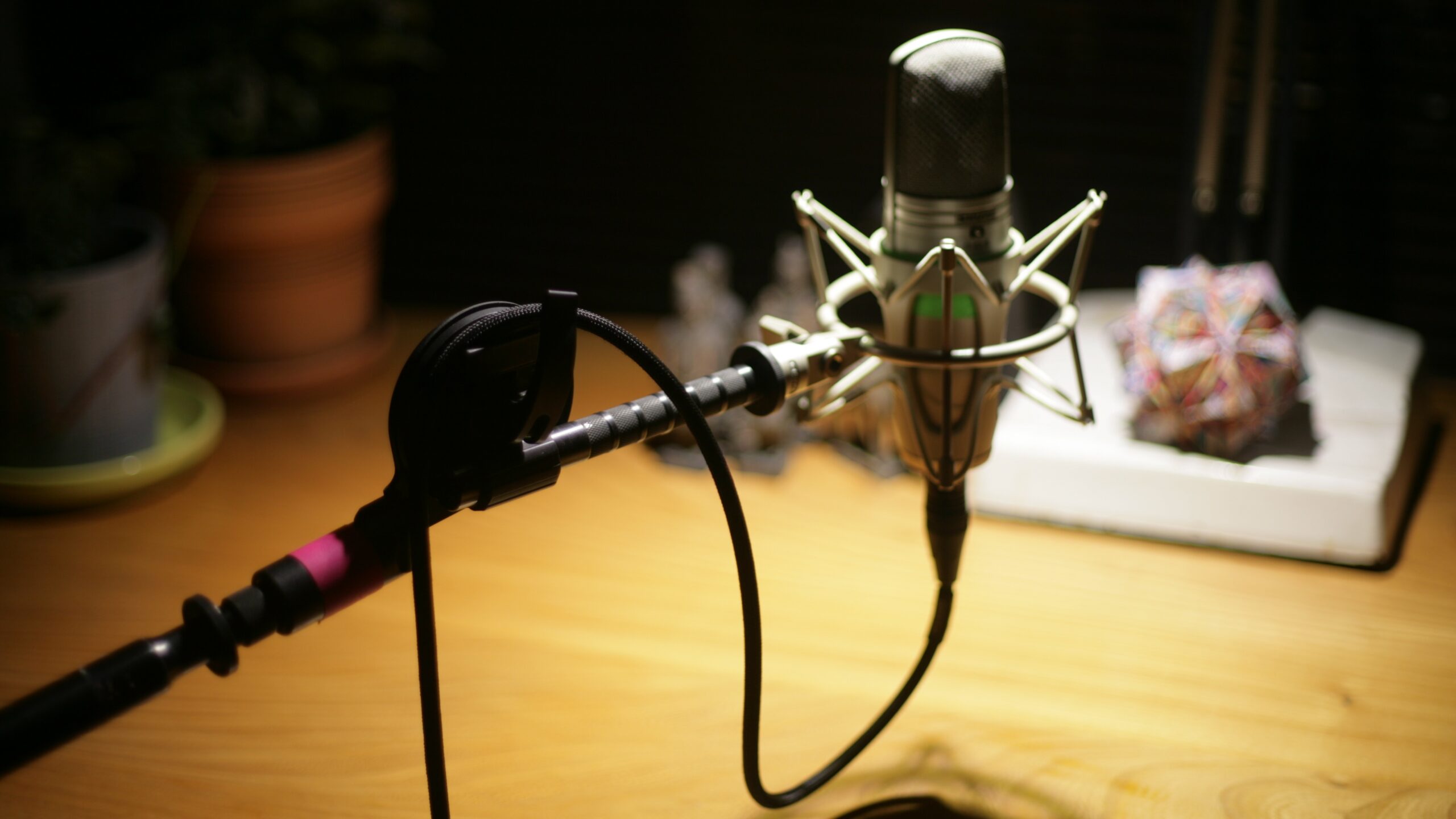 Photo of a microphone at a desk under a lamp.