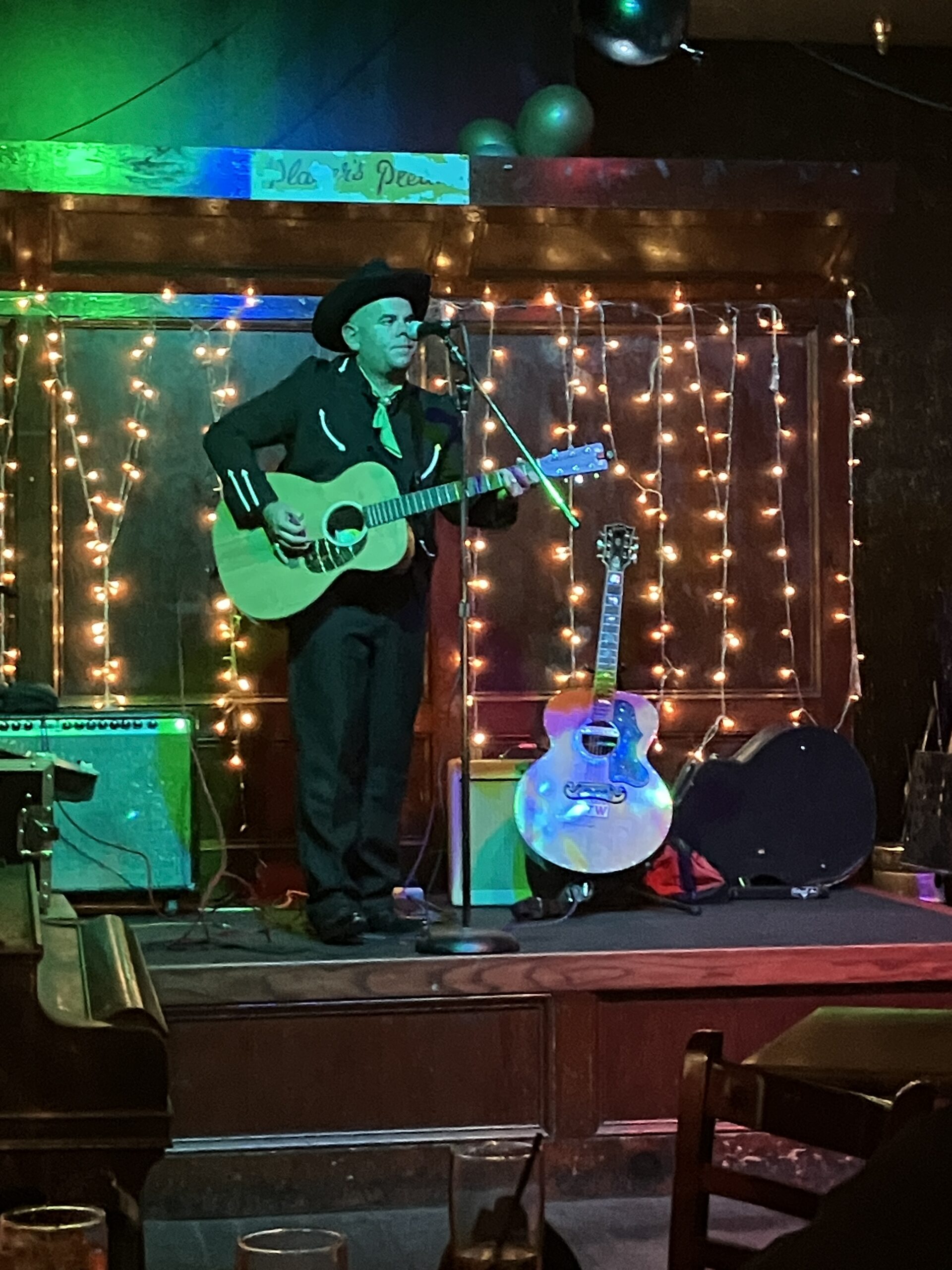 A singer songwriter on stage in western wear.